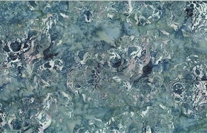 Batik fabric with a swirled water print in denim blue and soft green tones