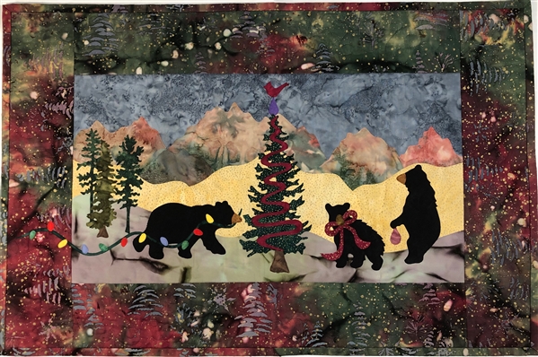 Quilt block of three bears in a snowy landscape decorating a tree for Christmas