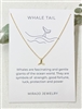 One Mirajo Jewelry whale tail necklace on a white cloth