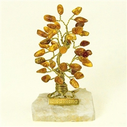 The leaves of this bonsai style tree are made with real polished amber stones attached to branches and trunk of twisted brass wire.  Assorted amber colors. The tree sits atop a piece of the finest Polish marble called "Marianna".