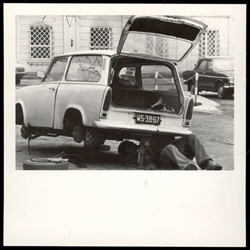 Repairing your own car was common in Communist Poland.  Times were tough and self-repairs were a good way to save money. 
Historical Black and White Photo Postcard