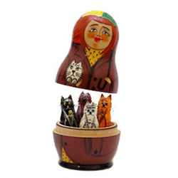 A winsome redheaded maid and her feline friend decorate this outer doll -- but wait, there's a surprise inside! When you open the doll, 4 different miniature cat figurines can be found. A delight for cat lovers.