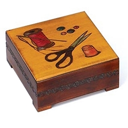 Sewing Box. This square box with feet features a sewing theme design featuring scissors, buttons, a thimble, a needle and thread with nice carved detail on three sides.  The inside bottom is lined with red felt.