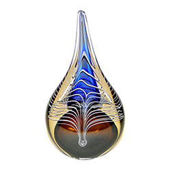 Two-sided art glass paperweight, with a gorgeous amber an dblue interior core with a peackock feather design, in a classic teardrop shape.  Each piece is hand blown and hand finished in Poland.  Made with the highest quality craftsmanship and hand-signed