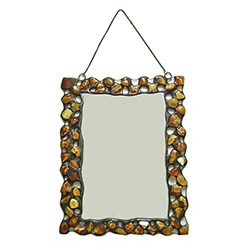 Hand made metal frame decorated with genuine natural amber stones.  There are three minor flaws in the mirror's edge so we are discounting.