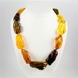 Stunning necklace composed of a variety of large multi-colored polished amber nuggets.  Each piece is separated by a knotting.