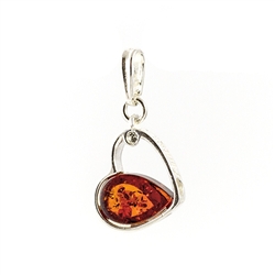 A heart of silver filled on one side with an amber cabochon, "Amber And  Love" stamped on the side and a clear crystal imbedded in the side.