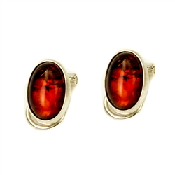 Beautiful pair of oval shaped cognac colored amber clip on earrings set in sterling silver.