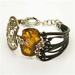 Antiqued silver highlights this beautiful amber centerpiece (1.25" x 1" x .2" - 3cm x 2.5cm x .5cm). Silver and black leather strands fits a wrist up to 8" - 20cm diameter (adjustable).