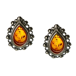 Artistic tear drop shaped silver earrings with a center of honey colored amber.