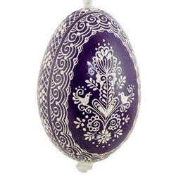 This beautifully designed egg is dyed one color, then white wax is melted and applied to form an intricate design which is left on the surfce. The egg is emptied and strung with ribbon for hanging.