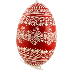 This beautifully designed egg is dyed one color, then white wax is melted and applied to form an intricate design which is left on the surfce. The egg is emptied and strung with ribbon for hanging.