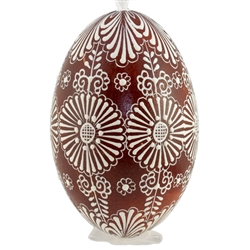 This beautifully designed egg is dyed one color, then white wax is melted and applied to form an intricate design which is left on the surfce. The egg is emptied and strung with ribbon for hanging.