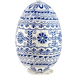 This beautifully designed egg is dyed one color, then white wax is melted and applied to form an intricate design which is left on the surfce. The egg is emptied and strung with ribbon for hanging.