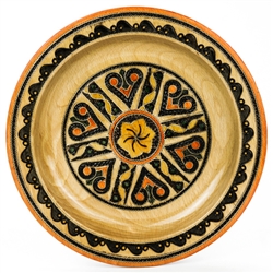 This Polish plate is made from beech wood in the mountain region of southern Poland called Podhale. The plates are cut and shaped on a lathe by hand. The designs are burned into the wood then painted after staining and varnishing. All the designs are