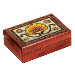 The lid of this box is decorated with a bright floral motif. A burned design around the edges of the lid and on the sides of the box completes the piece. The box is handmade in the Tatra Mountain region of Poland