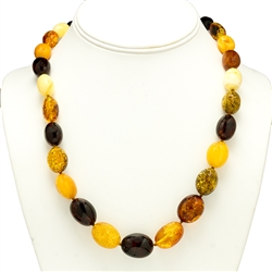 Natural Baltic Amber Cherry, Custard, Light and Dark Honey Amber Oval Amber Beads  Graduated sizes up to .75" long by .6" wide bronze colored cord w/ knot between each bead. Silver claw clasp closure.