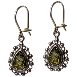 Artistic antique tear drop shaped silver earrings with a center of green colored amber. Size approx. 1" long.