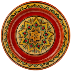 This Polish plate is made from beech wood in the mountain region of southern Poland called Podhale. The plates are cut and shaped on a lathe by hand. The designs are burned into the wood then painted after staining and varnishing. All the designs are