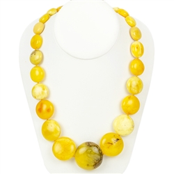 This beautiful beaded amber necklace features rounded disc shaped Baltic custard amber strung together and finished with an amber closure. The beads are knotted between each bead.