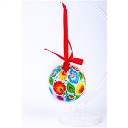 Folk art is the perfect souvenir from Poland. This ornament is inspired by the paper cuts from the Lowicz area of central Poland.  Lightweight, unbreakable plastic with a decorative Lowicz pattern. Comes with a red ribbon for handing. Size approx 3" dia