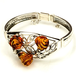 This stunning sterling silver bracelet features 3 hand carved honey amber roses blooming from their silver stems and leaves.