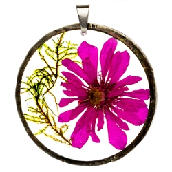 A hand made pendant made with flowers from fields in the Lubelskie region of Poland. Our flower has been dried and embedded in clear resin, then framed in a circle of tin plated copper and ready to hang. A lovely piece of handmade jewelry inspired by