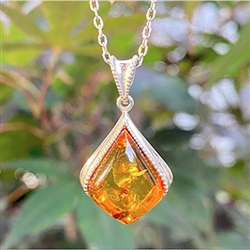 Sterling Silver with antique detail framing a beautiful honey amber cabochon.  Amber cabochon is approx  .75" x .75".