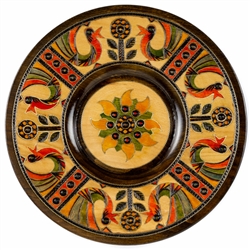 This Polish plate is made from beech wood in the mountain region of southern Poland called Podhale. The plates are cut and shaped on a lathe by hand. The floral designs are burned into the wood then painted after staining