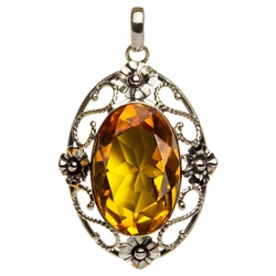 Sterling Silver with filigree detail surrounding a beautiful diamond cut honey amber cabochon.  Size is approx 2.2" x .1.4" x .5".