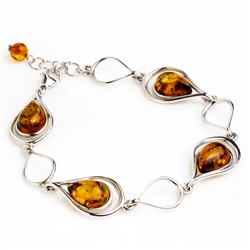 4 tear drop shaped amber beads each set in a sterling silver frame. Size is 7.5" diameter with a 1" extender.