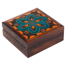 This square brown box has a turquoise flower on its lid, along with other accent designs. A swirling border runs along the sides of the box.