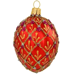 Shimmering in a vivid hue of ruby red with eye-catching accents, this stunning hand-painted ornament was inspired by the famous jeweled eggs of the House of Faberge, in St. Petersburg, Russia. A sparkling gold glitter diamond pattern with purple and