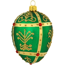 Shimmering in a bright hue of emerald green, this stunning glass ornament was inspired by the famous jeweled eggs of the House of Faberge, in St. Petersburg, Russia. Featuring dazzling gold glitter folk patterns surrounded by metallic gold lines studded