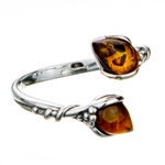 Sterling silver open ring highlighting two amber cabochons. Size is approx .5" x .25"