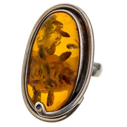 A beautiful amber cabochon framed in a classic sterling silver frame. Size is approx 1.5 x .75".