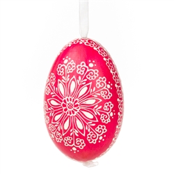 This beautifully designed egg is dyed one color, then white wax is melted and applied to form an intricate design which is left on the surfce. The egg is emptied and strung with ribbon for hanging.