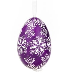 This beautifully designed egg is dyed one color, then white wax is melted and applied to form an intricate design which is left on the surfce. The egg is emptied and strung with ribbon for hanging.