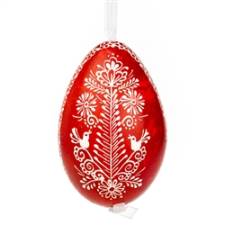 This beautifully designed egg is dyed one color, then white wax is melted and applied to form an intricate design which is left on the surfce. The egg is emptied and strung with ribbon for hanging.