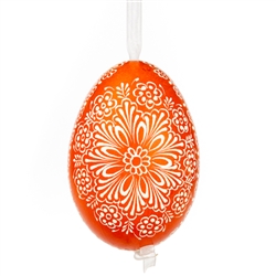 This beautifully designed egg is dyed one color, then white wax is melted and applied to form an intricate design which is left on the surfce. The egg is emptied and strung with ribbon for hanging.