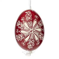 This beautifully designed egg is dyed one color, then white wax is melted and applied to form an intricate design which is left on the surfce. The egg is emptied and strung with ribbon for hanging.