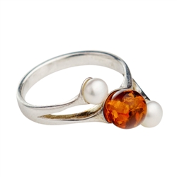 Stylish and delicate sterling silver ring with amber and pearl. Amber is very soft and in this setting must be treated with care.  Ring should be removed before washing your hand.
&#8203;