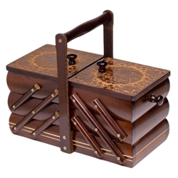 Polish sewing box with expandable pull-out drawers. Hand carved circular design on the top lids. Handle is removed for shipping.