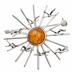 Charming brooch with birds in flight around a honey amber center.  Size is approx 1.5" diameter.