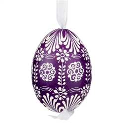 This beautifully designed egg is dyed one color, then white wax is melted and applied to form an intricate design which is left on the surfce. The egg is emptied and strung with ribbon for hanging.