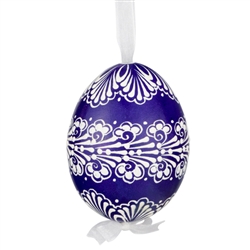 This beautifully designed egg is dyed one color, then white wax is melted and applied to form an intricate design which is left on the surfce. The egg is emptied and strung with ribbon for hanging.