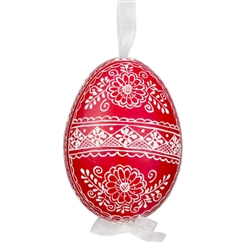 This beautifully designed egg is dyed one color, then white wax is melted and applied to form an intricate design which is left on the surfce. The egg is emptied and strung with ribbon for hanging.