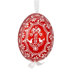 This beautifully designed egg is dyed one color, then white wax is melted and applied to form an intricate design which is left on the surfce. The egg is emptied and strung with ribbon for hanging.