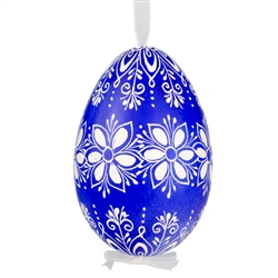 This beautifully designed egg is dyed one color, then white wax is melted and applied to form an intricate design which is left on the surfce. The egg is emptied and strung with ribbon for hanging.