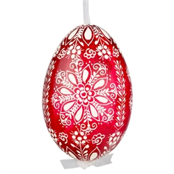 This beautifully designed egg is dyed one color, then white wax is melted and applied to form an intricate design which is left on the surfce. The egg is emptied and strung with ribbon for hanging.